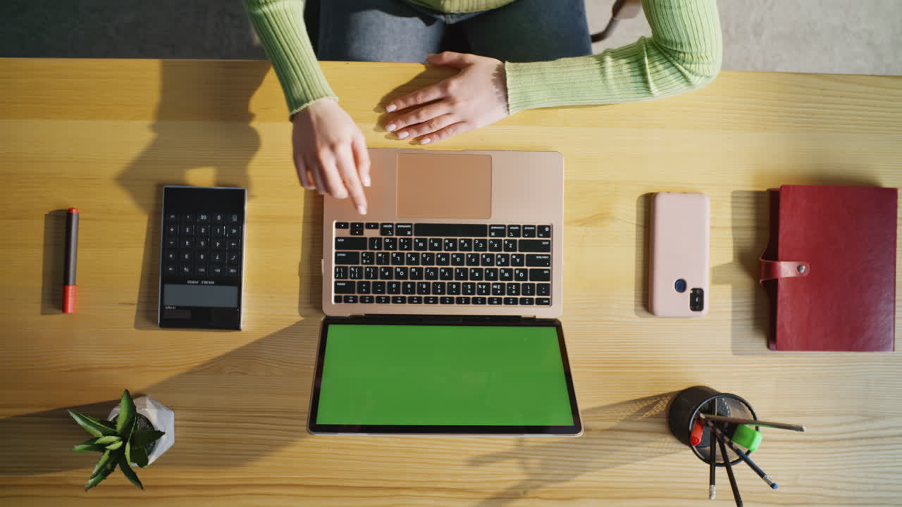 Woman finger pressing button texting green screen laptop at cabinet top view