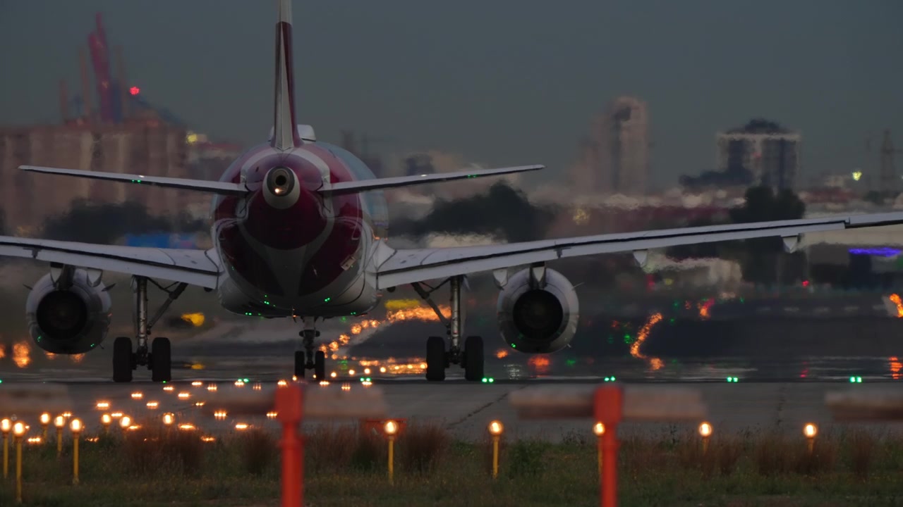 Aereo commerciale sulla pista al tramonto con luci colorate