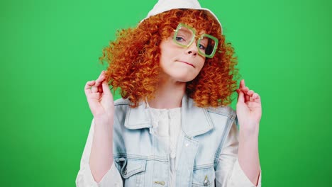 joven mujer pelirroja limpiándose, arreglándose el cabello y haciendo el gesto del beso, pov de espejo, fondo de clave de croma verde