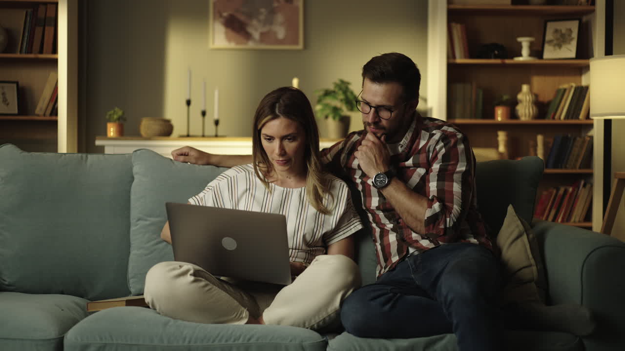 pareja usando una computadora portátil en casa