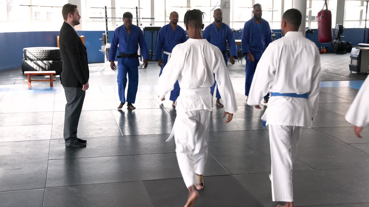 Practicing judo, group of men in uniforms standing in training hall