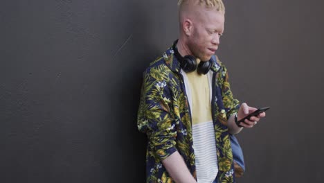 Nachdenklicher-Afroamerikanischer-Albino-Mann-Mit-Dreadlocks,-Der-Sein-Smartphone-Benutzt