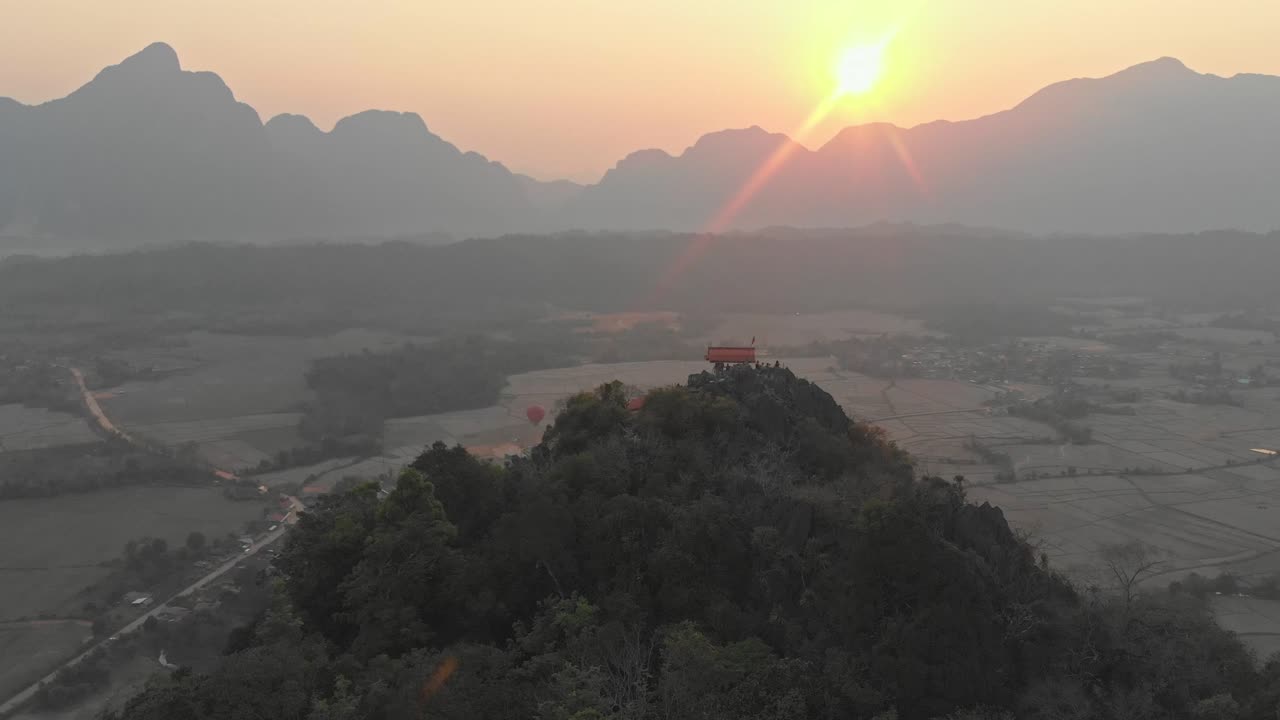 Flying forwards over viewpoint at Vang vieng Laos during sunrise, aerial