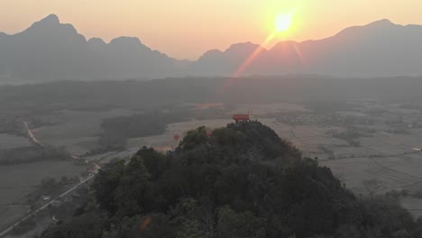 Flying-forwards-over-viewpoint-at-Vang-vieng-Laos-during-sunrise,-aerial