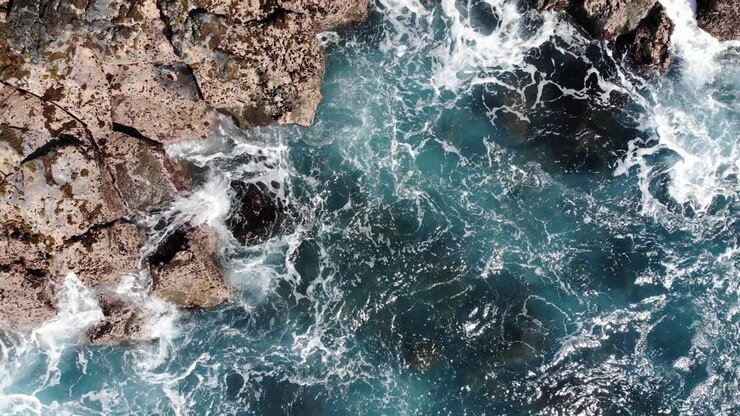 Onde che turbinano tra rocce formate da colate laviche sull'isola di Hawaii.