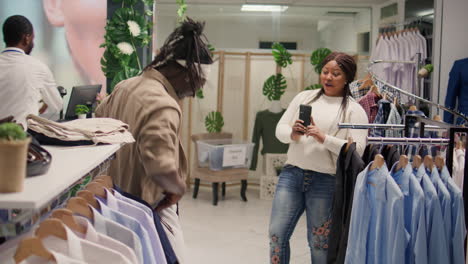 Woman-helps-man-pick-pants-in-mall