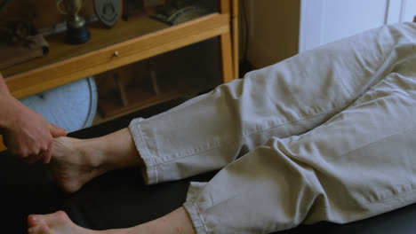 physiotherapist giving foot therapy to senior woman 4k