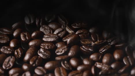 rotating shot of roasted coffee beans with smoke