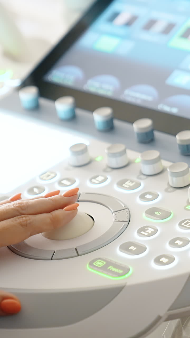 Female hand operating the modern ultrasonic equipment. Doctor presses buttons on the keyboard. Close up. Vertical video