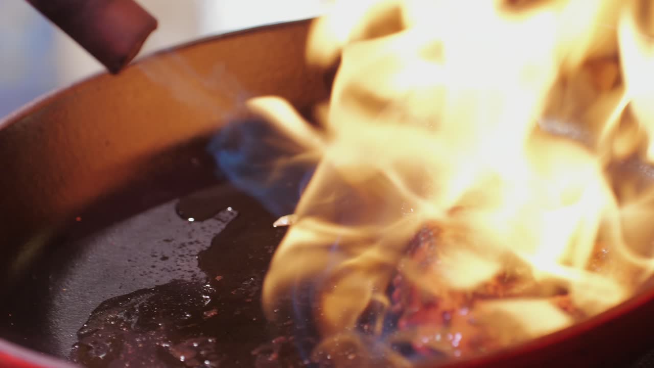 Capturing the art of flamb cooking in a vibrant cast iron skillet, showcasing dramatic flames
