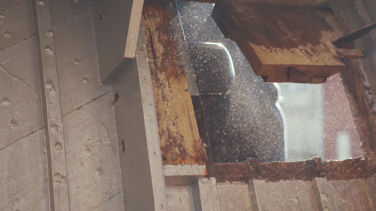 Handkreissäge schneidet durch verfaulte Mahagoniholzplanken eines Holzbootes