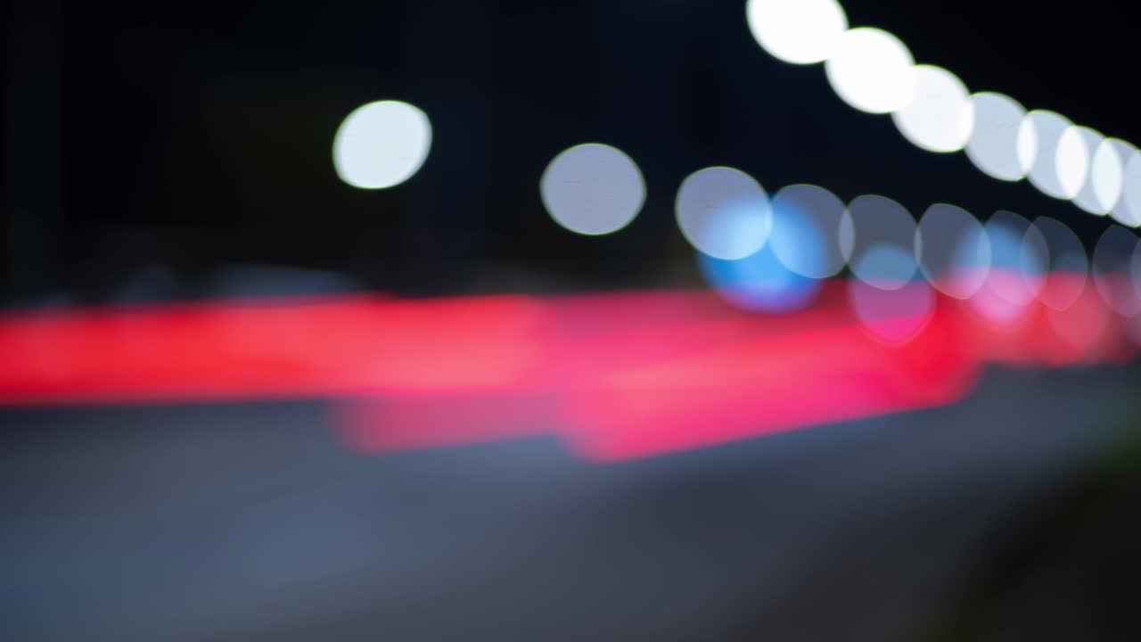 el lapso de tiempo de los semáforos nocturnos en la ciudad. hermoso bokeh en el fondo oscuro borroso por la noche. uhd, 4k