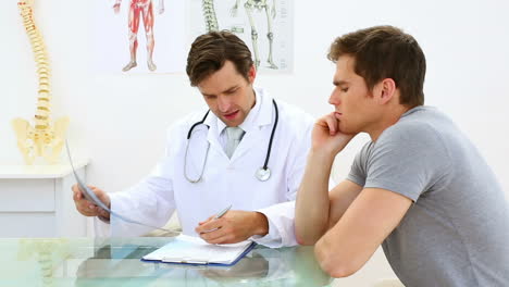 smiling doctor discussing xray with his patient