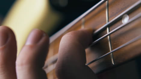 person plays bass guitar applying pitch shift technique