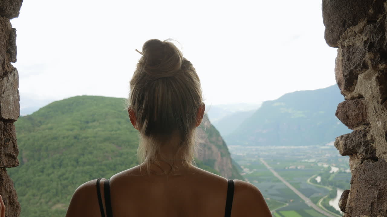 Young pretty girl enjoying beautiful landscape view over italian mountains and nature