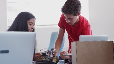 Schüler-Mit-Männlichem-Lehrer-Im-Computer-Codierungskurs-Nach-Der-Schule-Lernen,-Roboterfahrzeuge-Zu-Programmieren