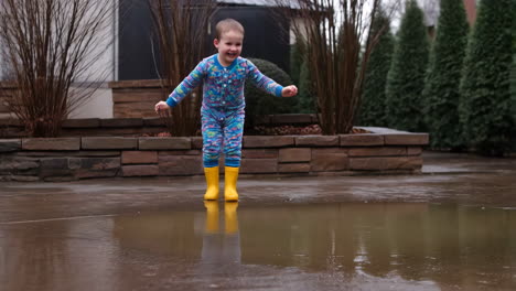 a child jumps and splashes joyfully in a puddle