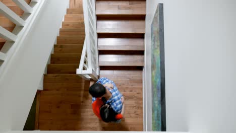 Father-holding-his-daughter-while-walking-down-through-staircase-4k