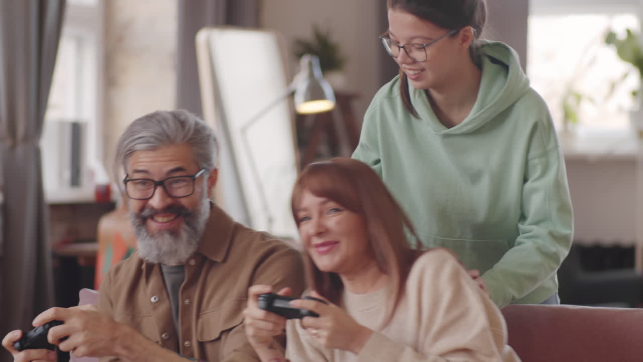 una niña alegre viendo a sus padres jugando a un videojuego en la consola