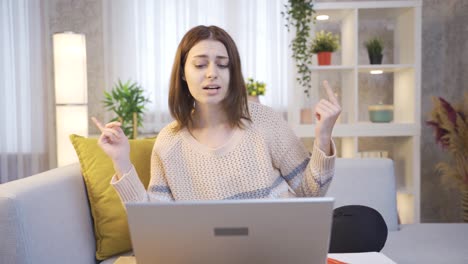 estudiante en casa sentada en el sofá y estudiando en la computadora portátil, escuchando música y bailando.