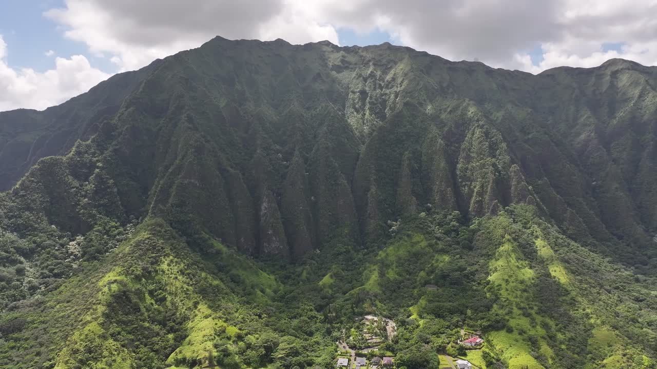 Aerial drone footage over Hawaii’s lush green mountains and tropical coastline, showcasing turquoise ocean waters, palm trees, scenic valleys, and the island’s vibrant natural landscapes from above