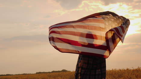 Fröhliche-Frau-Läuft-über-Weizenfeld-Mit-USA-Flagge