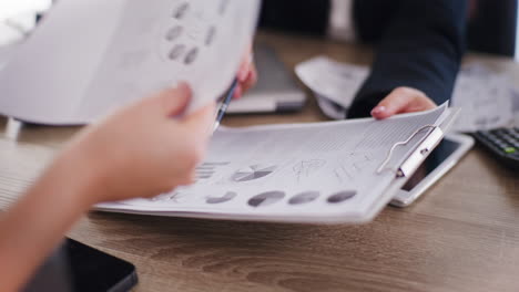 primer plano de las manos de la mujer analizando el informe financiero