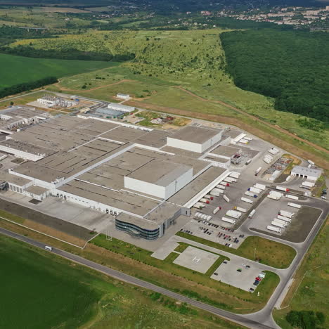 aerial view to modern factory in the countryside. large industrial area among green fields. manufacturing complex outdoors.