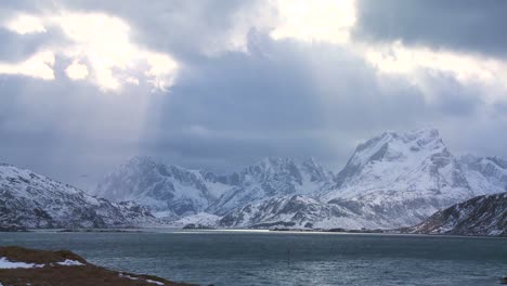 Heavenly-light-streams-down-on-a-beautiful-snow-covered-shoreline-amidst-fjords-north-of-the-Arctic-Circle-in-Lofoten-Islands-Norway-1