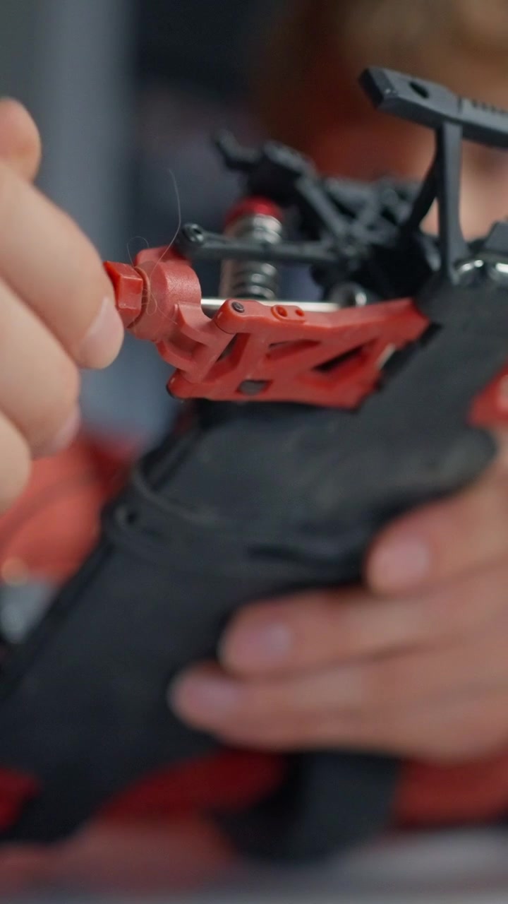 Close-up of a Person Assembling a Remote Control Car