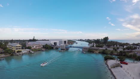 Carretilla-Delantera-Aérea-De-Barcos-Que-Cruzan-La-Bahía-En-La-Playa-De-Nokomis-Y-Se-Acercan-Al-Puente-Levadizo