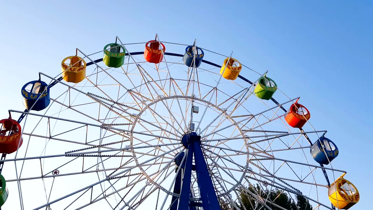 нижний вид колеса обозрения над голубым небом