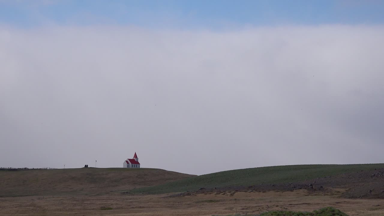 아이슬란드의 광대한 열린 공간에 있는 작은 아이슬란드 교회나 예배당 위에 있는 구름의 저속 촬영