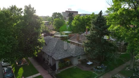 quaint house with a fenced yard on a tree-lined suburban street at sunset