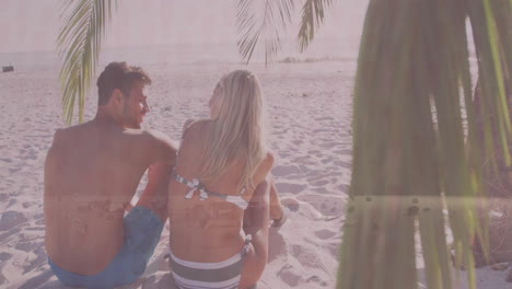 sitting on sandy beach under palm tree, couple watching animation on tablet