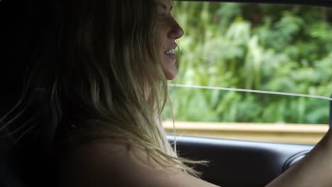 mujer atractiva conduciendo por una carretera rural sonriendo