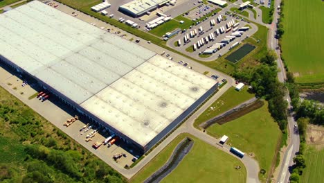 aerial view of warehouse storages or industrial factory or logistics center from above. top view of industrial buildings and trucks