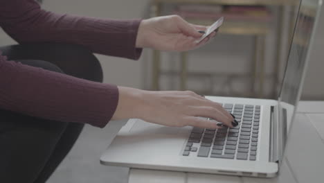 Zeitlupenaufnahme-Einer-Frau,-Die-Kartendetails-In-Einen-Laptop-Eingibt-Und-Daumen-Nach-Oben-Gibt,-Wenn-Sie-Den-Kauf-Abschließt---Unbenotet