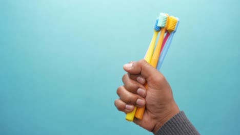 la mano con pinceles de dientes de colores