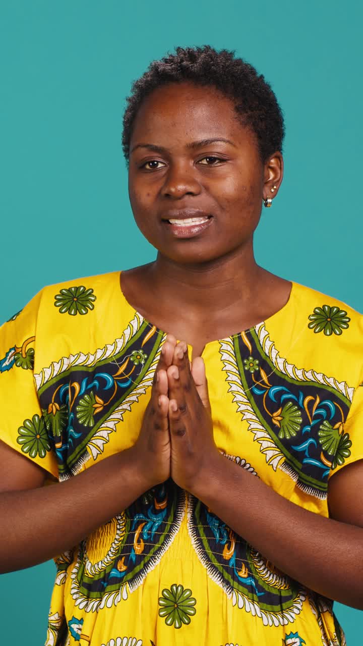 African Woman Meditating with Prayer Hands in Studio