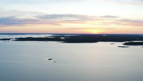 Aerial,-rising,-drone-shot,-tilting-towards-the-silhouette-coast-of-Porkkala,-in-the-archipelago-of-Finland,-Gulf-of-Finland,-on-a-sunny,-summer-evening,-in-Porkkalanniemi,-Uusimaa,-Suomi