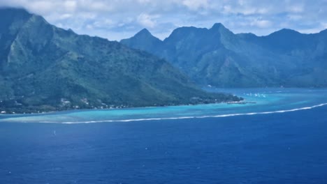 moorea island french polynesia picturesque coastline, lagoon and volcanic hills, airplane passenger pov