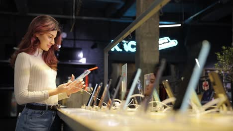 a woman is currently looking at a cell phone while in a store in a store a woman is intently looking at a cell phone contemplating her options and possibly considering a purchase