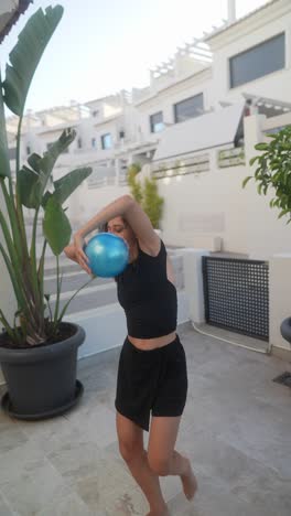 woman playing with a blue ball outdoors