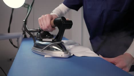 Cropped-View-Of-A-Female-Worker-Ironing-Clothes