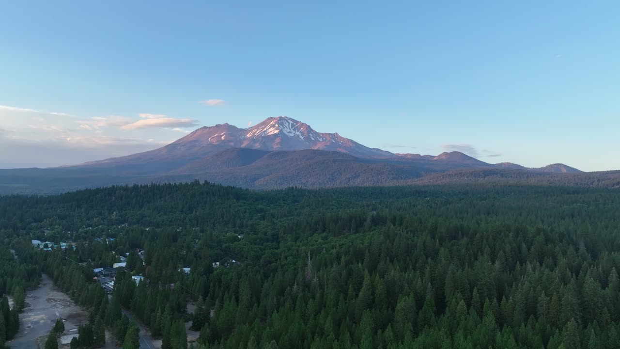 Panoramica aerea con drone che ruota attorno al Monte Shasta innevato, tramonto in Oregon, USA