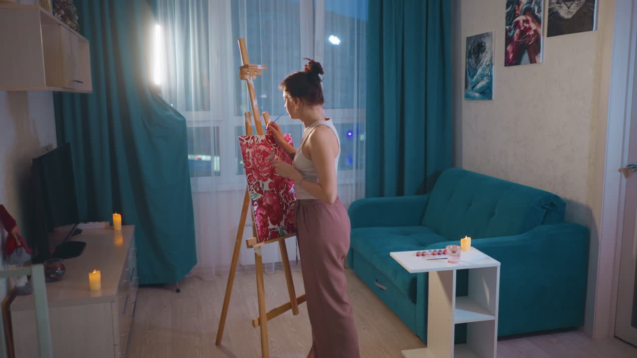 Young Caucasian Woman Preparing Canvas For Tutorial In Warm Apartment Studio, Setting Palette And Brushes Near Window Light, Adjusting Easel For Livestream Recording, Camera Ready Composition And Calm