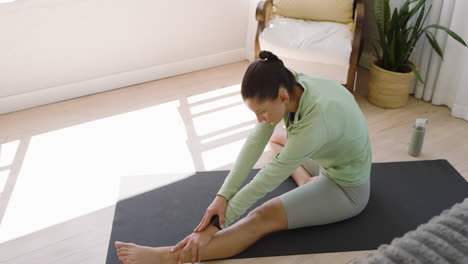 woman practicing yoga on mat at home, focusing on stretching exercises, copy space