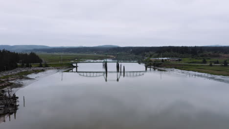 drone ascending over the coquille river, showing the the bullards bridge near bandon, oregon