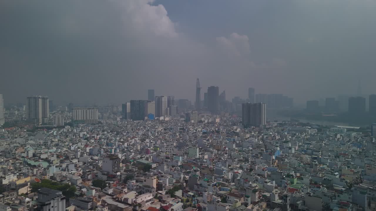 Aerial view of Ho Chi Minh City skyline with high density urban area in foreground with dramatic morning sky. Flying backwards high over rooftops